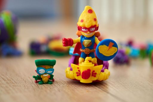 A Super Things Kazoom Kids toy figurines on a wooden table.