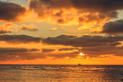 A beautiful cloudy sunset with a boat in the distance in the Baltic sea near Klaipeda, Lithuania
