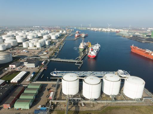 An aerial view of the oil petrochemical storage silos and large transportation vessels on a sunny day in West Haven, Netherlands