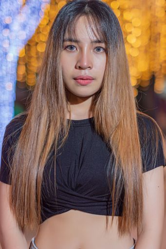 Aportrait of a beautiful young Southeast Asian girl with black top posing in the street