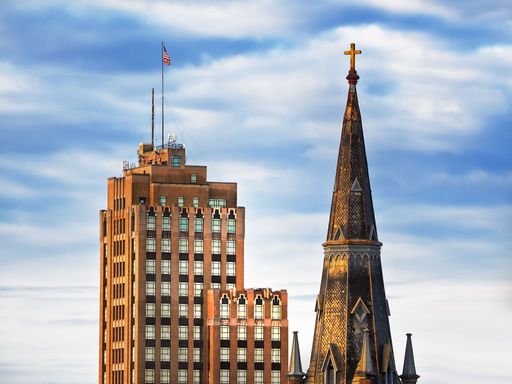 Sackets Harbor, New York, USA. April 23, 2022. The steeple of St. Paul Episcopal Cathedral and The State Tower Building in downtown Syracuse, NY