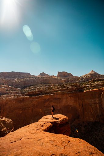 A vertical shot of the woman standing on the edge of the cliff. Grand Canyon National Park, USA.
