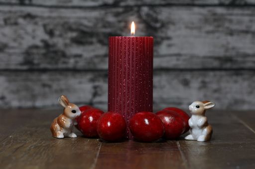 A closeup shot of a red burning candle Festive composition with Easter eggs with a copy space