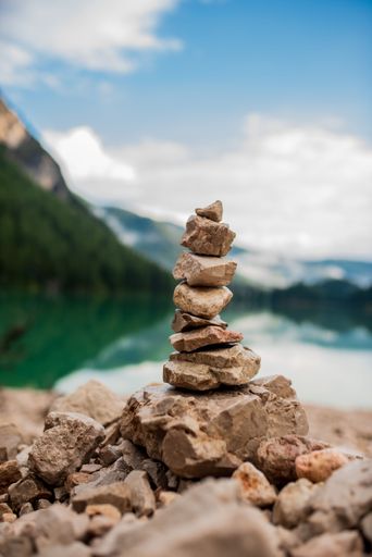 A vertical shot of small stones stacked on top of each other on the shore