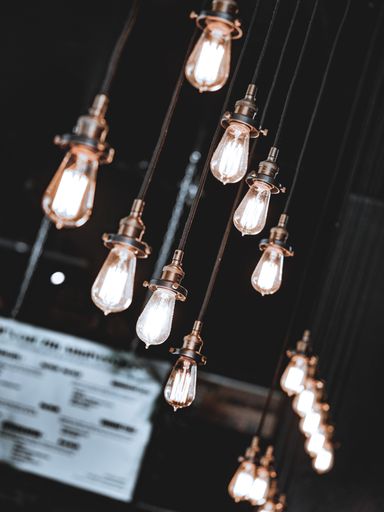 A vertical shot of glowing vintage led light bulbs on a dark background