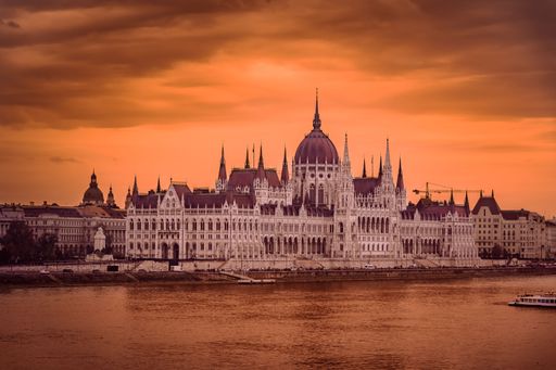 The beautiful exterior design of Hungarian Parliament Building with sea view during sunset