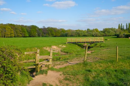 open farmland stream wooden stile and bridge next to Monton village Eccles Manchester UK