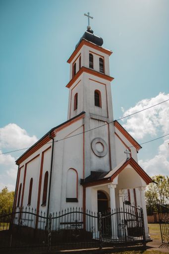 A vertical shot of a beautiful church surrounded by a fence under the clear sky