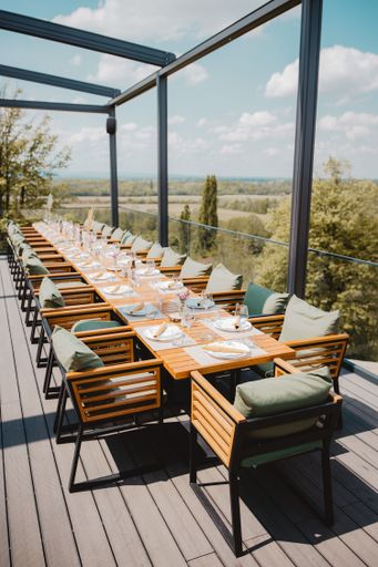 A vertical shot of a long table for a party on the terrace with a beautiful view of nature