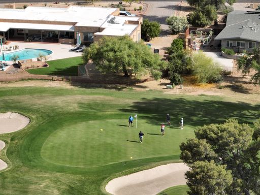 An aerial view of people playing golf on a sunny day
