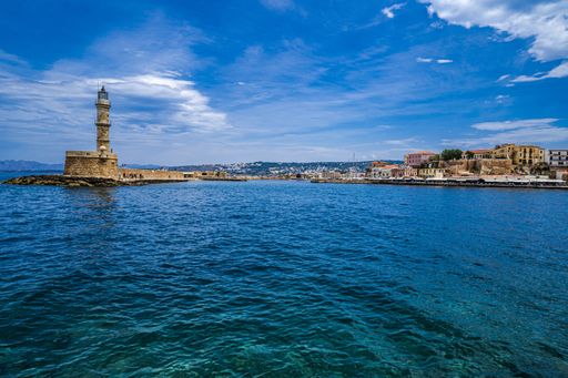 The image shows the entrance to the old Venetian harbor and the lighthouse at Chania, the second largest city in Crete