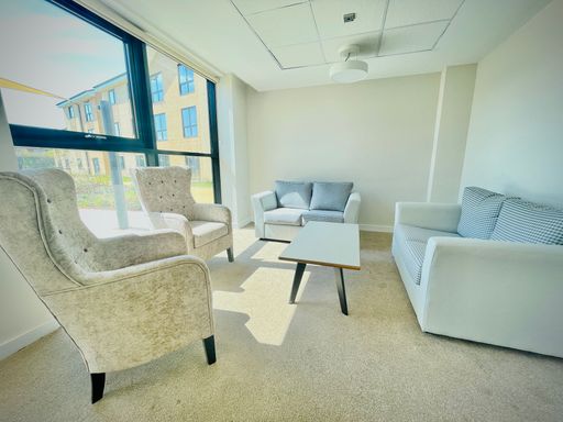 An interior of a seating area with grey sofas and chairs