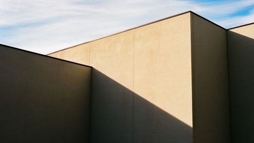 a shot of gray modern building against blue sky