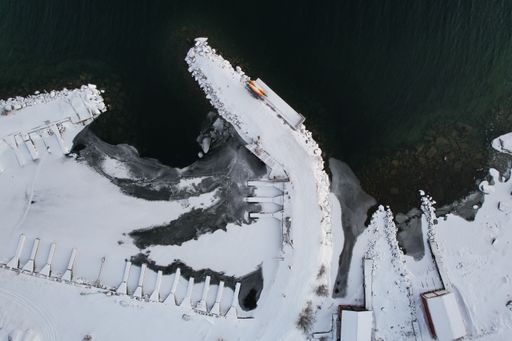 An aerial view of buildings on the lakeshore covered with snow in winter