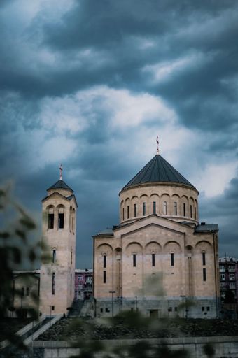 Vertical shot of Holy Cross Church in Arabkir District, Yerevan, Armenia. Scenic view, gloomy clouds over the dome of church, in evening