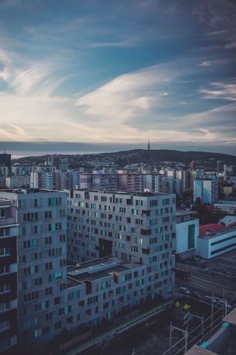 A vertical shot of beautiful urban landscape with many modern buildings against a blue cloudy sky