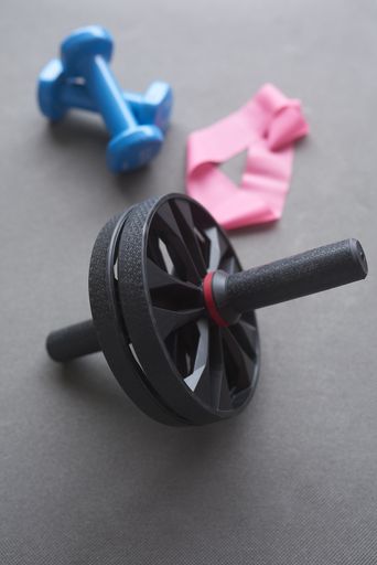 A vertical shot of gym accessories placed on a grey floor - perfect for background