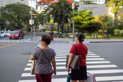 Two pedestrians waiting to cross the road outside the Glorietta Mall