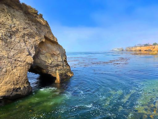 cove with a rock formation in the water