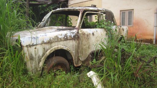 A closeup shot of an abandoned old car outdoors