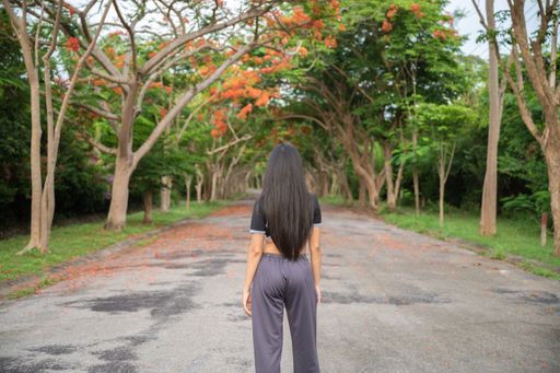 A beautiful South Asian girl with long hair standing in the middle of a street