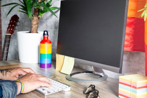 A close-up shot of a man working in an office with LGBT accessories