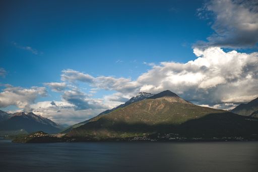 A scenic view of the sea and coastline mountains under the cloudy sky