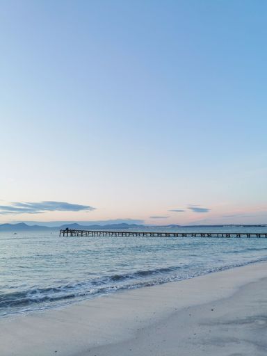 A vertical shot of a beautiful sunrise sky over Alcudia beach in Mallorca island, Spain