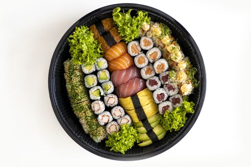A top view of big sushi set in black plastic box on a white background