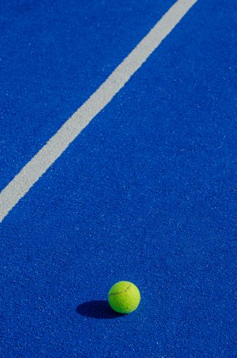 Isolated ball on a blue paddle tennis court