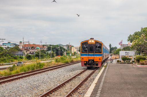 A train pulls into a station and waits for passengers in Thailand