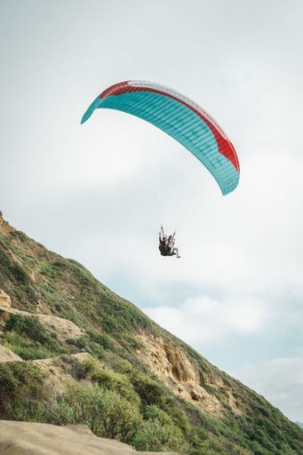 A paraglider over a mountain during a gloomy sky