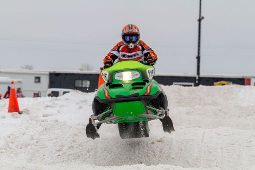 Snowmobiler competing in extreme sports. Snowmobile jumps above the track. On a snowmobile, a sportsman.  Motorsports in the snow