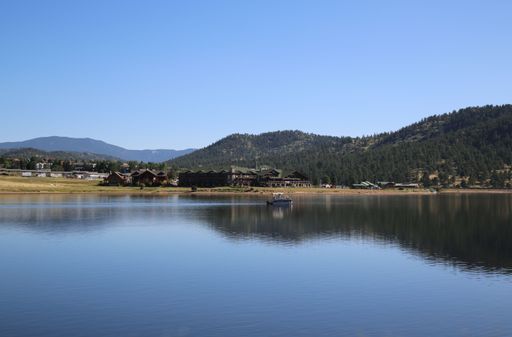 A scenic view of houses on shore of a lake against Rocky Mountains in Colorado, USA