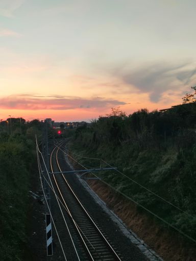 a vertical shot of railway going against the sunset