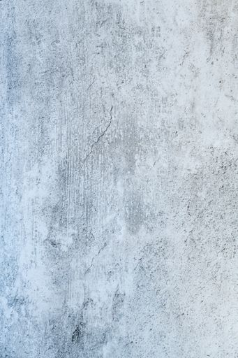 A vertical shot of a white concrete surface with grunge and copy space