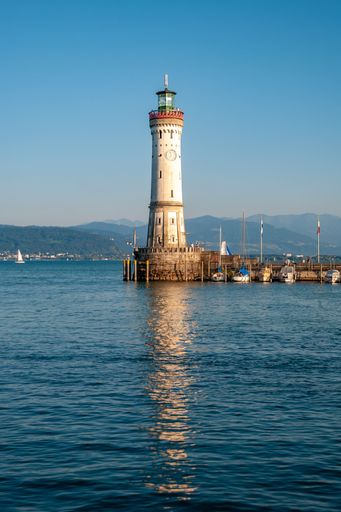 A vertical shot of a lighthouse against a blue sky in the beautiful Lindau, Germany