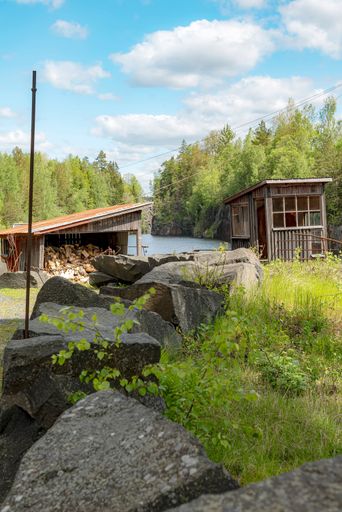 A vertical shot of old wooden cabins at the Black Mountains open-air museum in Traneboda, Sweden