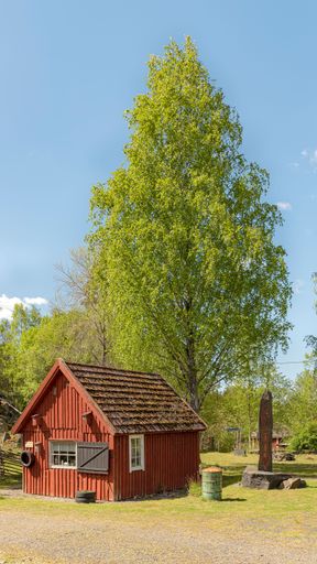 A vertical shot of an old wooden hut at the Black Mountains open-air museum in Traneboda, Sweden