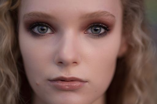 A closeup shot of a beautiful blonde female with blue eyes and a natural makeup