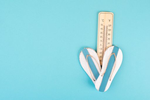 Empty blue background with a thermometer and flip flops, holiday background, summer vacation, hot weather, beach items