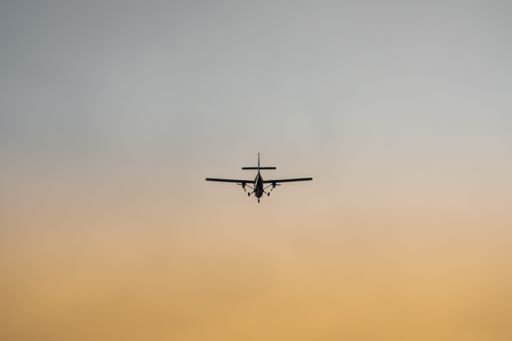 A closeup shot of a plane flying in the sky during sunset