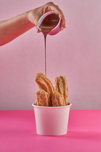 A full container of pretzels with chocolate