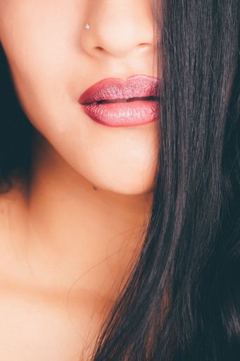 A closeup shot of a female wearing red lipstick - great for an article about cosmetics