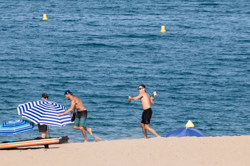 A group of young people having a good time under the sun on the beach in Pals, Spain