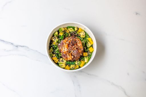 The top view of a bowl of poke -healthy salad with raw fish and veggies