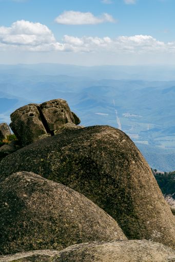 A vertical shot of a breathtaking view of rocky hills covered with moss on a sunny day