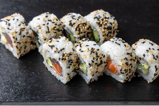 Eight pieces of sushi rolls on a black wooden board