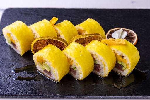 Eight pieces of sushi rolls on a black wooden board
