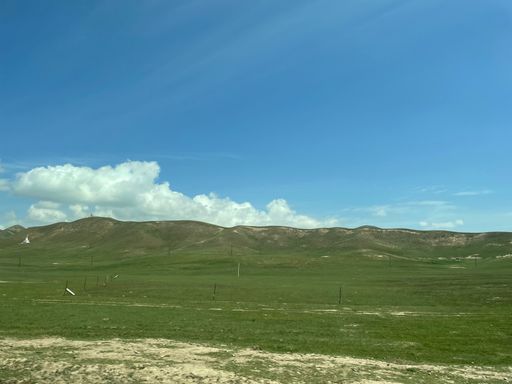 a shot of green hills against blue sky